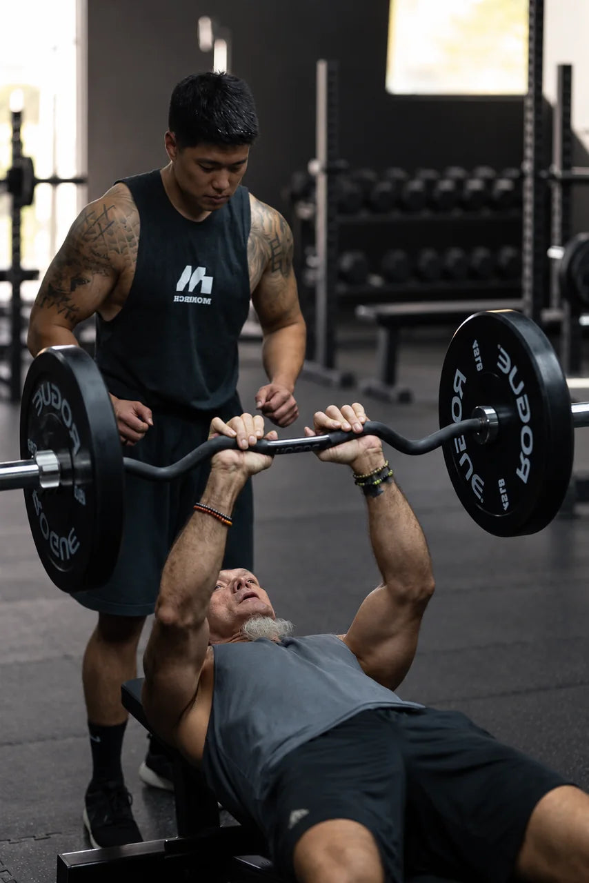 A MONARCH coach spotting a client during a bench exercise