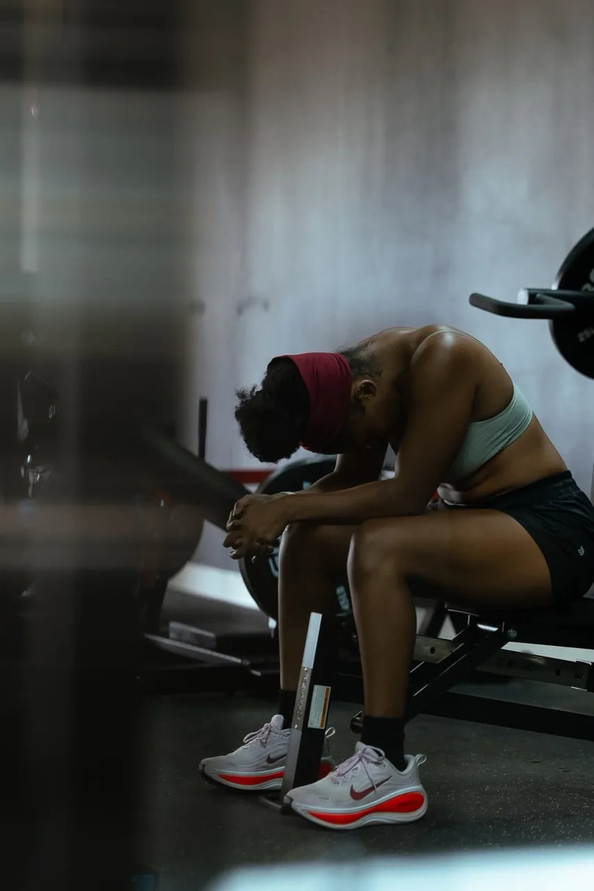 An athlete seated on a bench, resting between sets